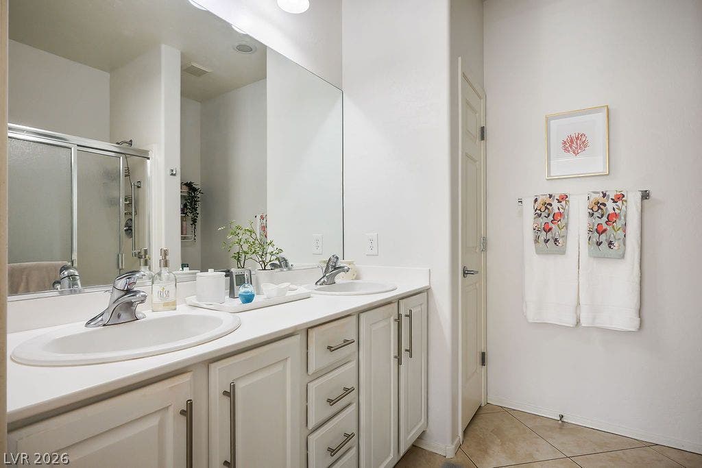 A spacious double vanity and tile flooring highlight this comfortable bathroom.