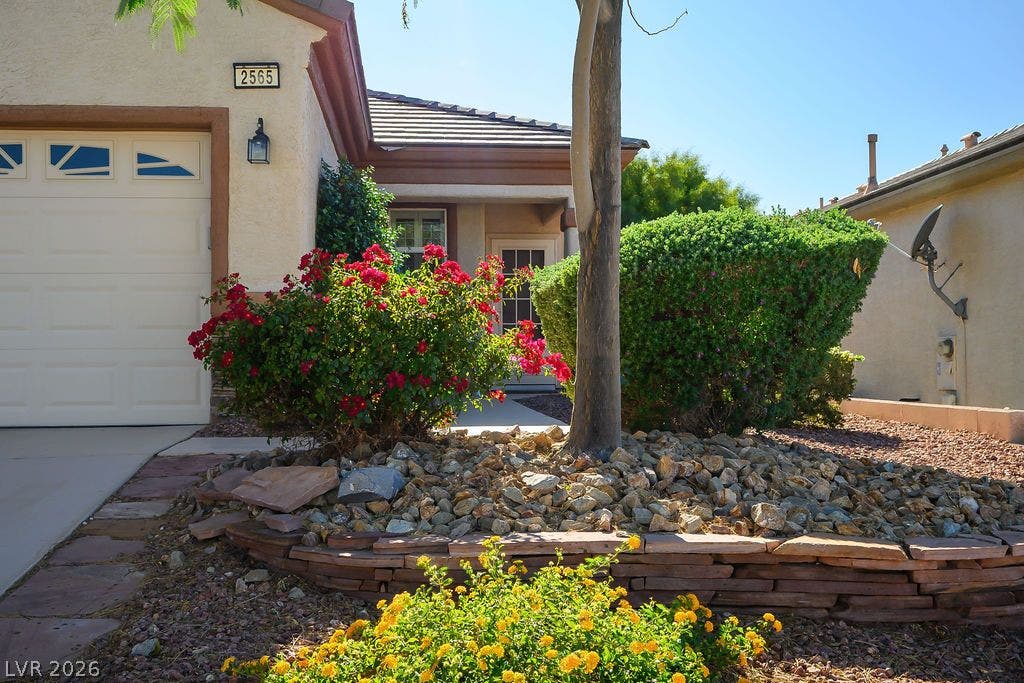 Lush desert landscaping lines the stone-edged path leading to a private front entrance.