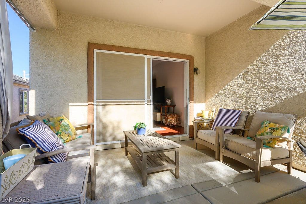 An inviting covered patio features stucco walls and sliding doors leading inside.