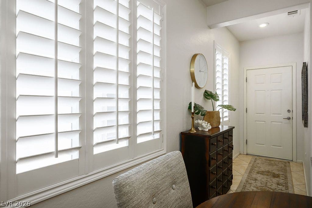 Crisp plantation shutters filter natural light into this welcoming entryway.