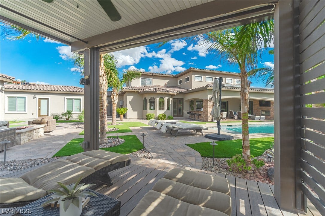 240 San Salvador Avenue, Henderson, NV 89002 An inviting covered patio transitions seamlessly to a paved pool terrace framed by palm trees.