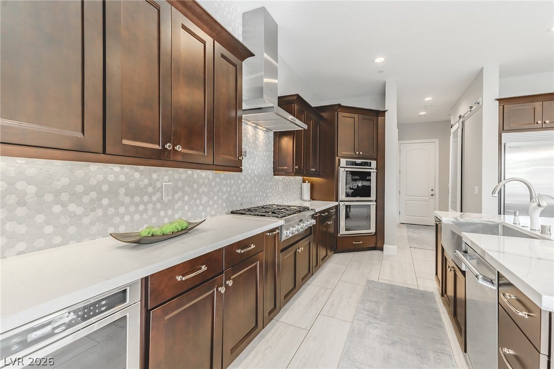 240 San Salvador Avenue, Henderson, NV 89002 Rich wood cabinetry contrasts beautifully with pale stone countertops and tiled flooring.