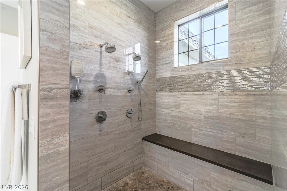 240 San Salvador Avenue, Henderson, NV 89002 Floor-to-ceiling tilework and a built-in bench highlight this custom walk-in shower.