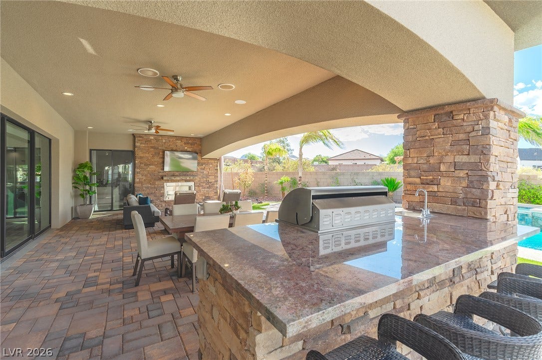 240 San Salvador Avenue, Henderson, NV 89002 An expansive covered patio features stone accents, a built-in barbecue station, and polished stone counters.