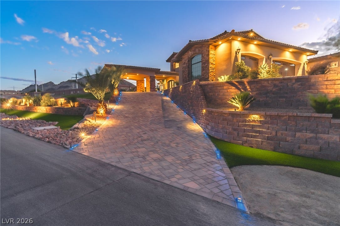 240 San Salvador Avenue, Henderson, NV 89002 An illuminated paver driveway leads to this elevated desert estate with stone accents.