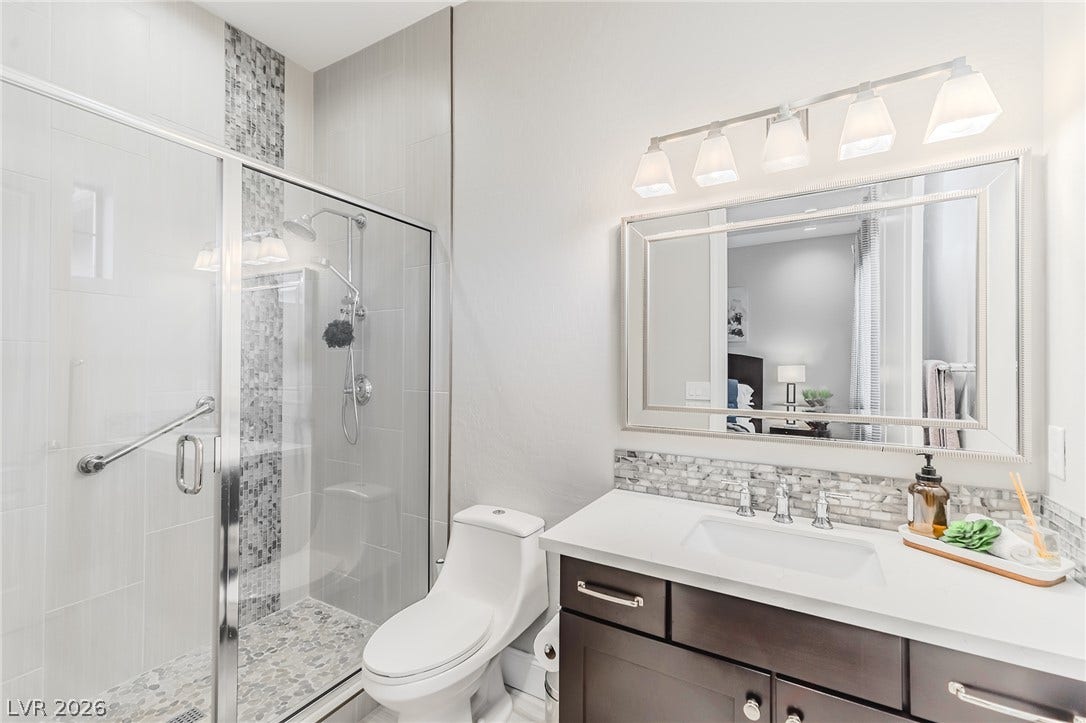 240 San Salvador Avenue, Henderson, NV 89002 A glass-enclosed walk-in shower highlights this modern washroom featuring stone countertops and clean finishes.