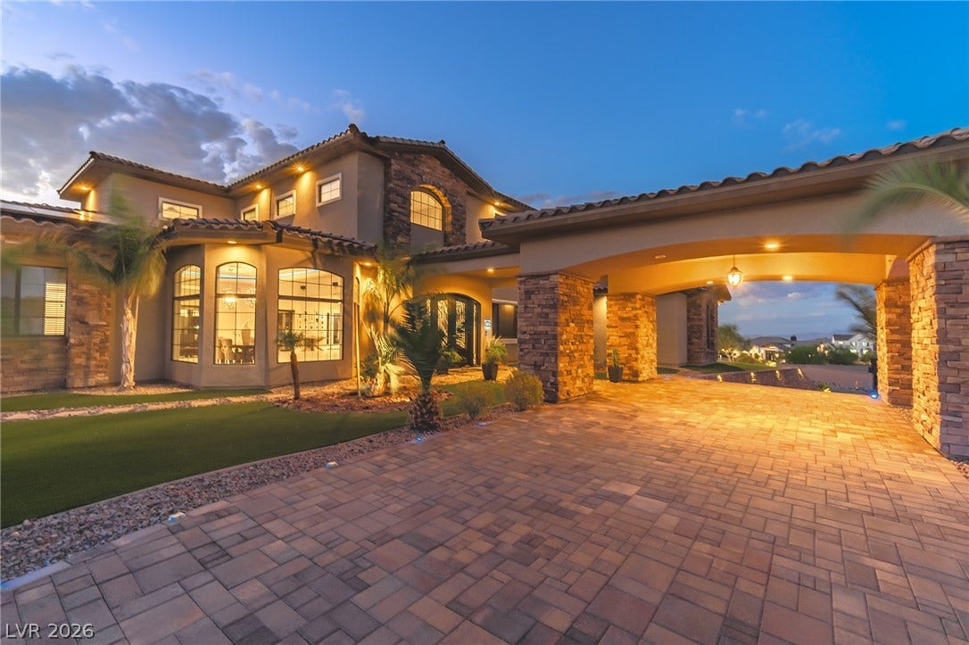 240 San Salvador Avenue, Henderson, NV 89002 An elegant paver driveway leads under a covered porte-cochere alongside stone-accented architecture.