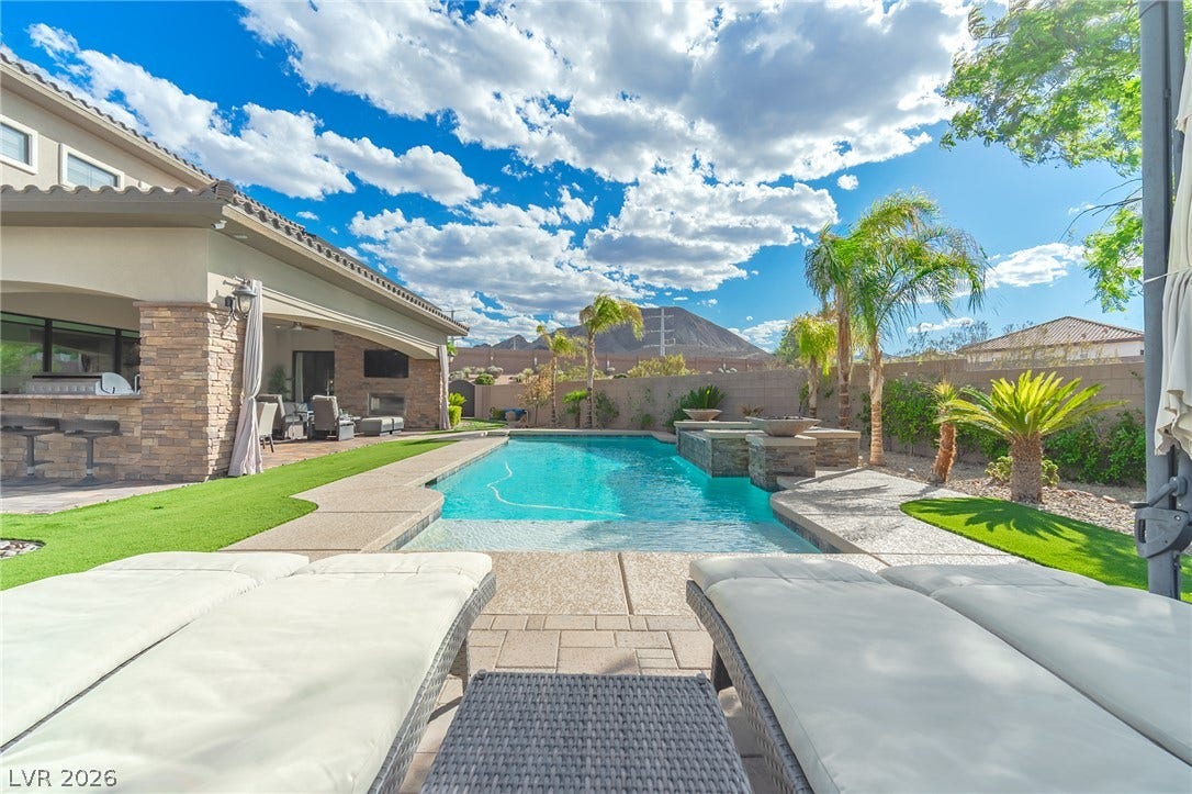 240 San Salvador Avenue, Henderson, NV 89002 An inviting backyard oasis features a pristine swimming pool framed by scenic mountain views.