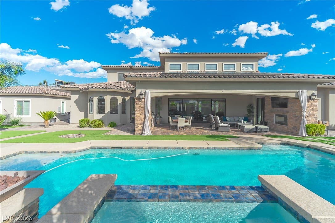 240 San Salvador Avenue, Henderson, NV 89002 A sparkling swimming pool and an integrated spa face a covered patio and stone columns.