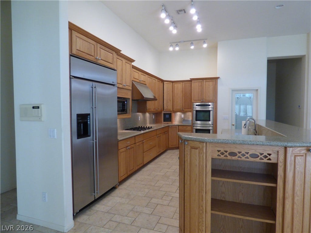 7695 Gilespie Street, Las Vegas, NV 89123 Gleaming stainless steel appliances complement warm wood cabinetry and a spacious kitchen island.