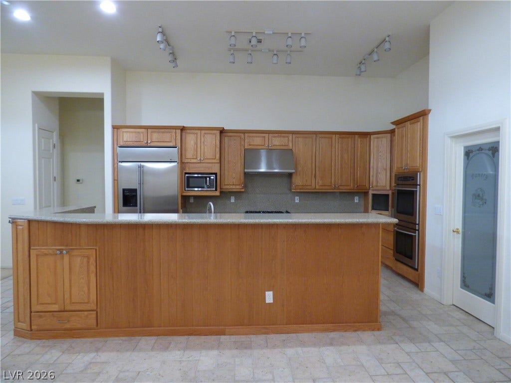 7695 Gilespie Street, Las Vegas, NV 89123 Ample wooden cabinetry and stone countertops anchor this functional cooking space.