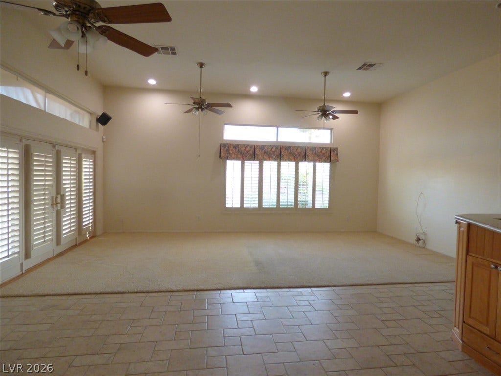 7695 Gilespie Street, Las Vegas, NV 89123 A spacious carpeted living area features high ceilings and French doors with plantation shutters opening to the pool area.