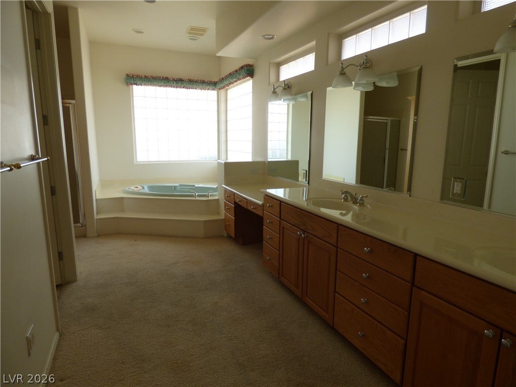 7695 Gilespie Street, Las Vegas, NV 89123 High windows invite natural light into this spacious primary bathroom featuring a large soaking jettet tub.