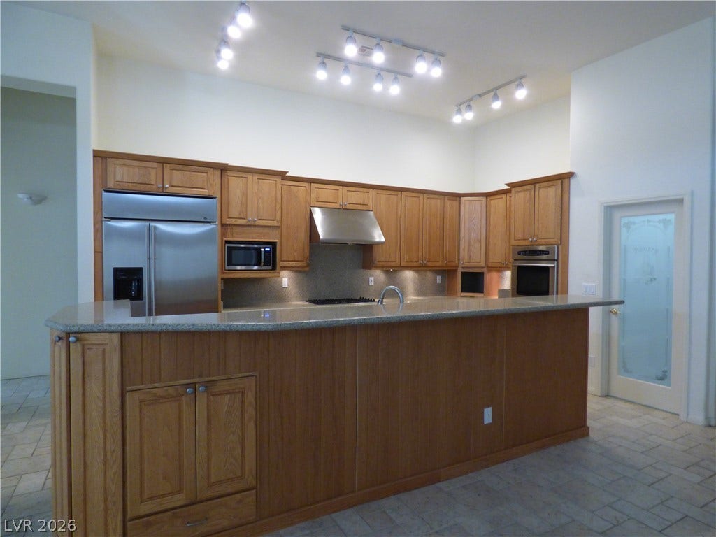 7695 Gilespie Street, Las Vegas, NV 89123 Ample wooden cabinetry and a spacious breakfast bar define this open-plan culinary workspace.