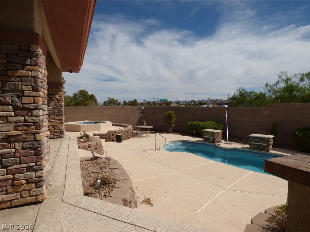 7695 Gilespie Street, Las Vegas, NV 89123 A spacious backyard oasis features an in-ground swimming pool and an adjacent spa. The outdoor kitchen is a plus for entertaining.