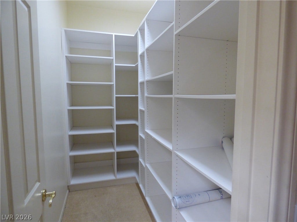 7695 Gilespie Street, Las Vegas, NV 89123 Floor-to-ceiling built-in shelving maximizes storage capacity within this carpeted walk-in closet space.