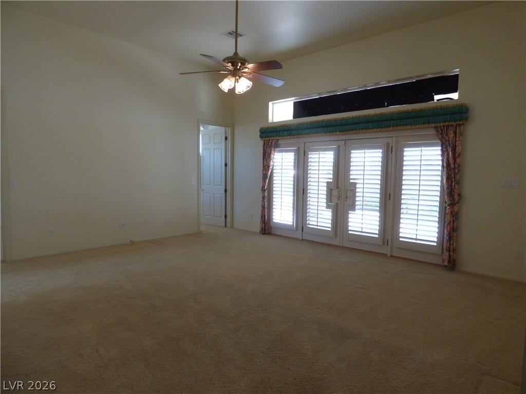 7695 Gilespie Street, Las Vegas, NV 89123 Soft carpeting pairs with soaring ceilings and glass doors opening to the outdoors.