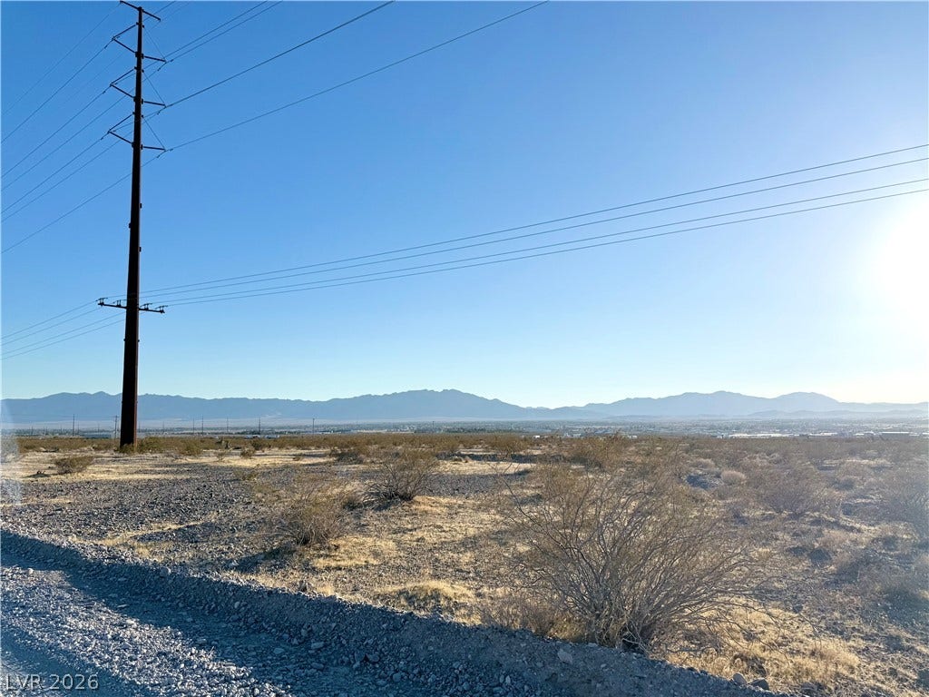 180 N Higley Road, Pahrump, NV 89060 Distant mountains frame this open desert acreage under a clear blue sky.