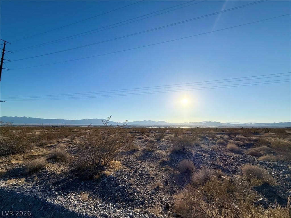 180 N Higley Road, Pahrump, NV 89060 Distant mountains frame this vast desert lot under a clear and open sky.