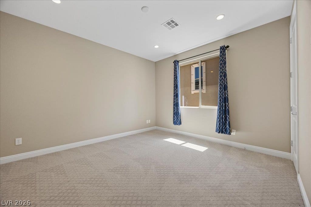 12021 Abbracci Avenue, Las Vegas, NV 89138 A well-lit, neutral-toned room features patterned carpeting and recessed lighting.