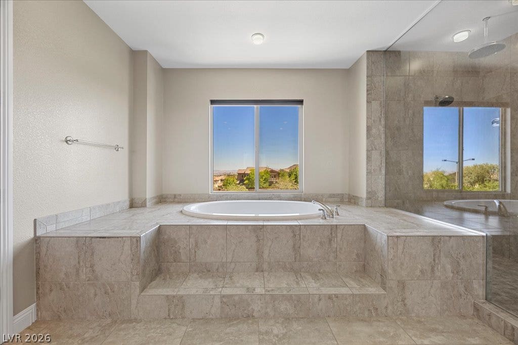 12021 Abbracci Avenue, Las Vegas, NV 89138 Indulge in relaxation within this primary bathroom, featuring a deep soaking tub and a separate glass-enclosed shower.
