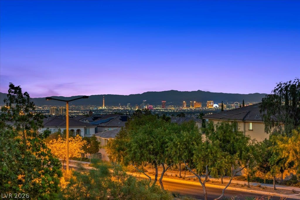 12021 Abbracci Avenue, Las Vegas, NV 89138 View from primary Balcony City lights twinkle beyond mountain ranges, offering a captivating evening panorama.