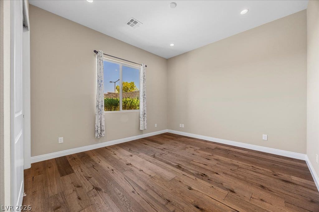 12021 Abbracci Avenue, Las Vegas, NV 89138 Well-lit interior space showcasing richly textured hardwood flooring and views of green landscaping.
