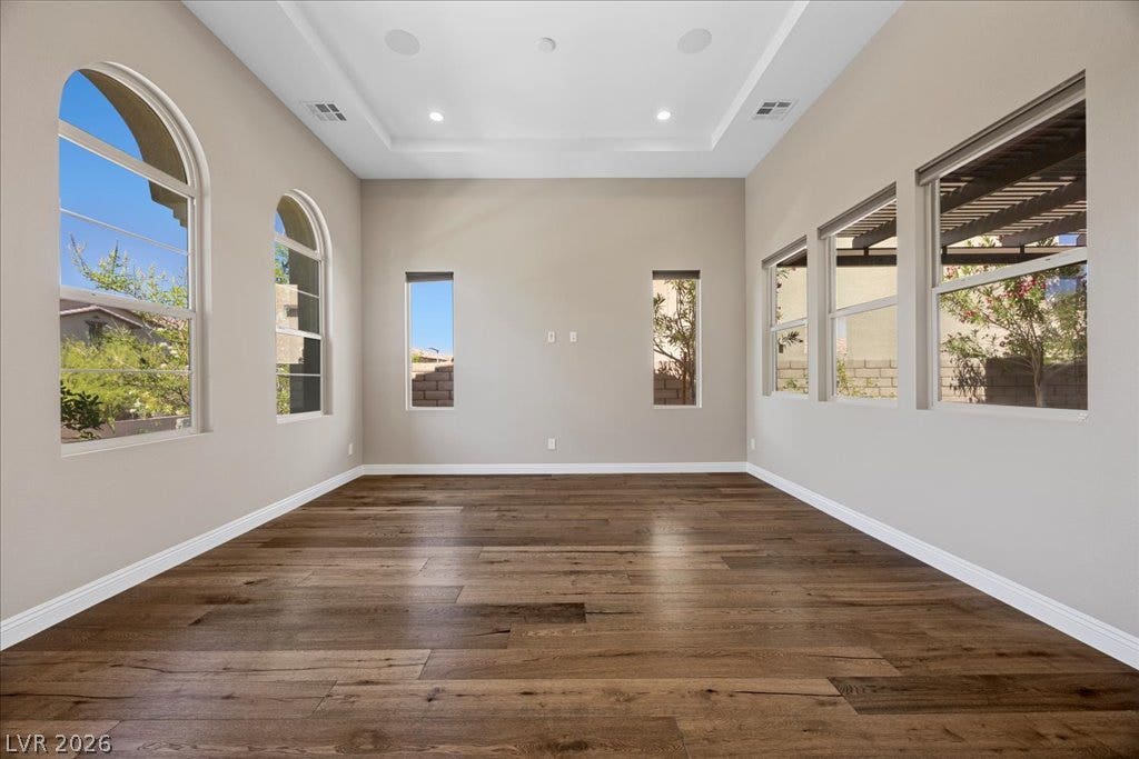 12021 Abbracci Avenue, Las Vegas, NV 89138 Rich hardwood flooring complements a tray ceiling and recessed lighting in this versatile room.