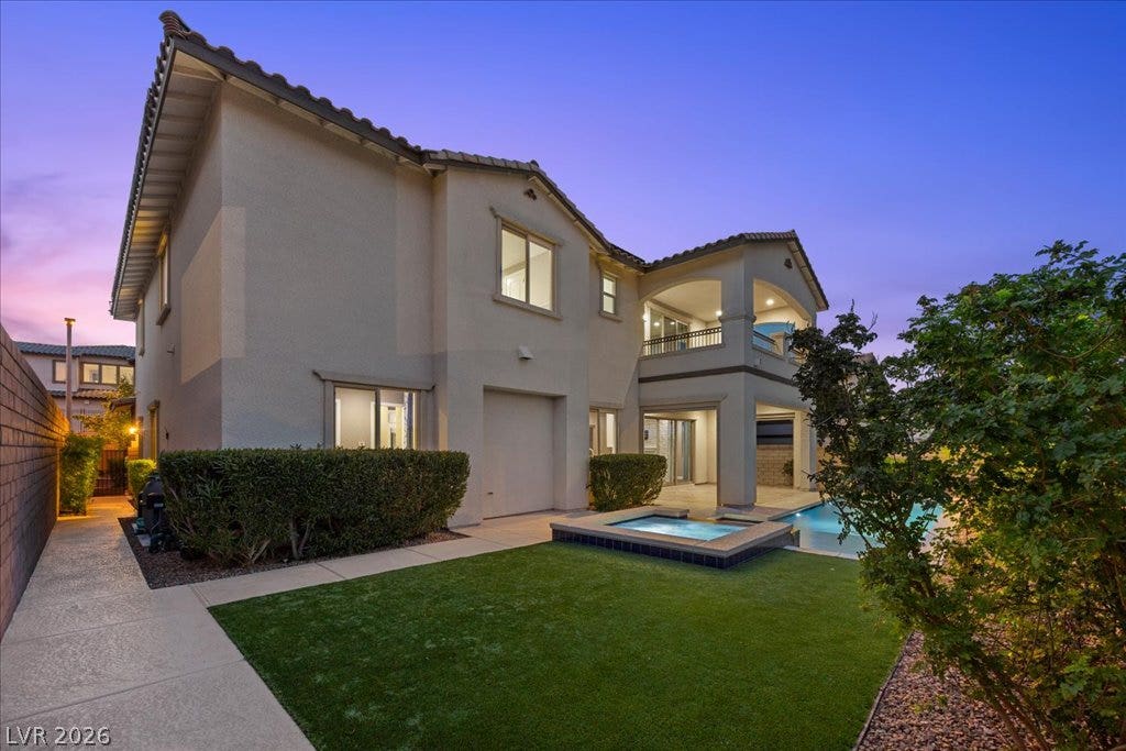 12021 Abbracci Avenue, Las Vegas, NV 89138 A spacious backyard retreat features a shimmering pool, relaxing spa, and artificial turf lawn.