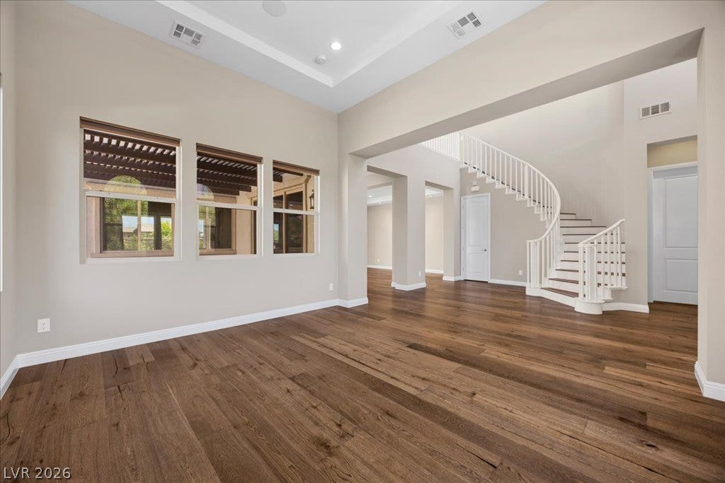 12021 Abbracci Avenue, Las Vegas, NV 89138 Grand entryway with rich hardwood floors welcomes guests, highlighted by an elegant curved staircase.