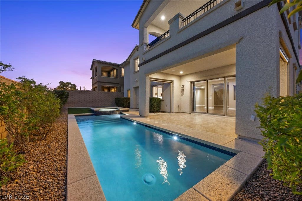 12021 Abbracci Avenue, Las Vegas, NV 89138 An inviting backyard oasis with a pristine pool awaits evening relaxation.