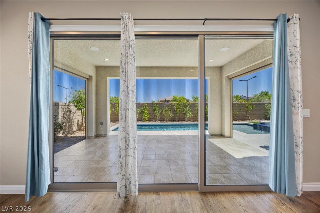12021 Abbracci Avenue, Las Vegas, NV 89138 Sliding glass doors open to a refreshing pool and outdoor living area, perfect for entertaining.
