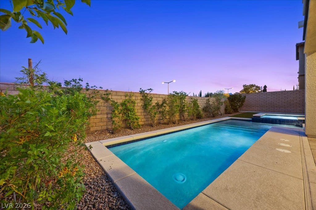 12021 Abbracci Avenue, Las Vegas, NV 89138 An inviting backyard oasis offers a serene pool and spa, perfect for evening relaxation.