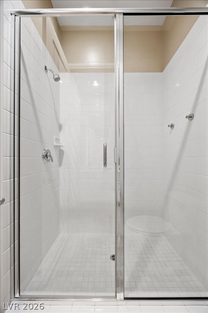 12021 Abbracci Avenue, Las Vegas, NV 89138 A spacious shower with crisp white tilework and clear glass enclosure for a refreshing start to your day.