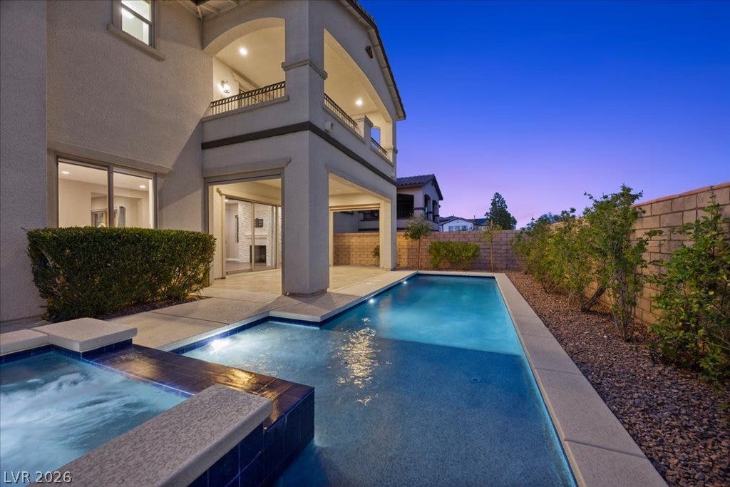 12021 Abbracci Avenue, Las Vegas, NV 89138 An inviting backyard oasis offers a sparkling pool and relaxing spa, perfect for evening enjoyment.