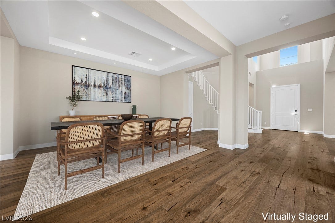 12021 Abbracci Avenue, Las Vegas, NV 89138 Virtually Staged Hardwood floors flow through this dining area, featuring tray ceilings and recessed lighting, leading to a grand entry and staircase.