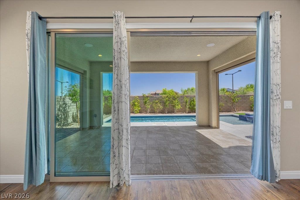12021 Abbracci Avenue, Las Vegas, NV 89138 Sliding glass doors reveal an inviting pool area, perfect for sun-drenched days.