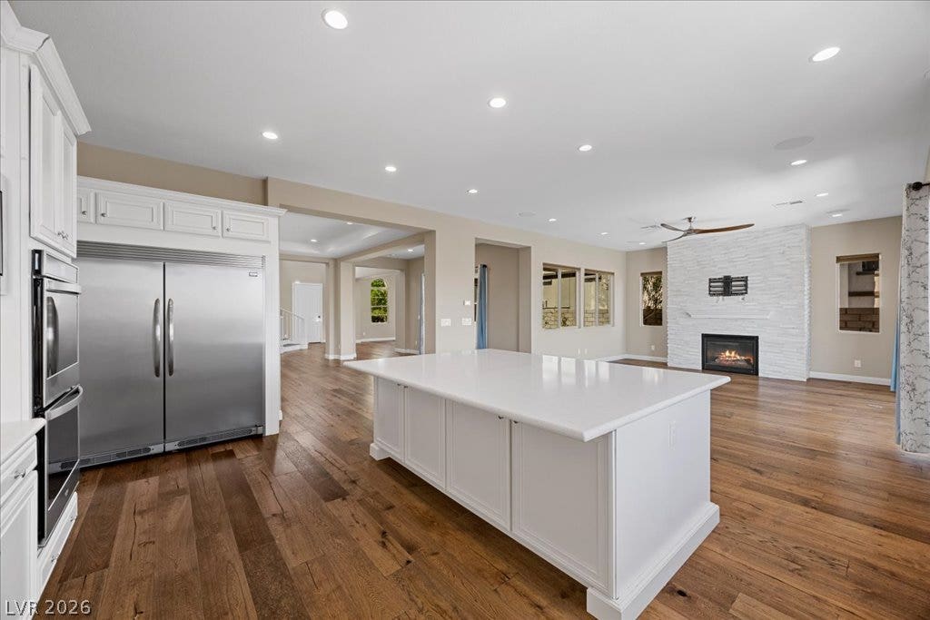 12021 Abbracci Avenue, Las Vegas, NV 89138 A spacious, open-concept living area with a gourmet kitchen island and an inviting fireplace.