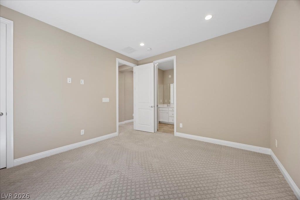12021 Abbracci Avenue, Las Vegas, NV 89138 A quiet bedroom with new carpet features easy access to a private bathroom.