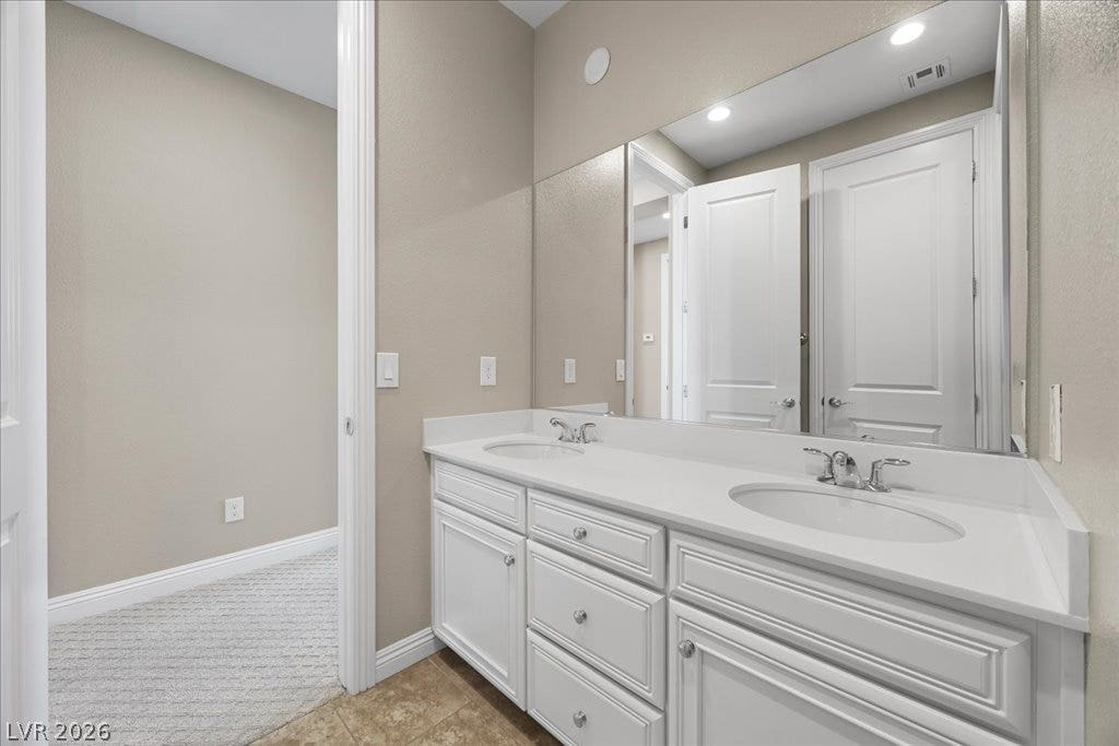12021 Abbracci Avenue, Las Vegas, NV 89138 Dual vanity sinks set in bright white cabinetry provide ample space for morning routines.