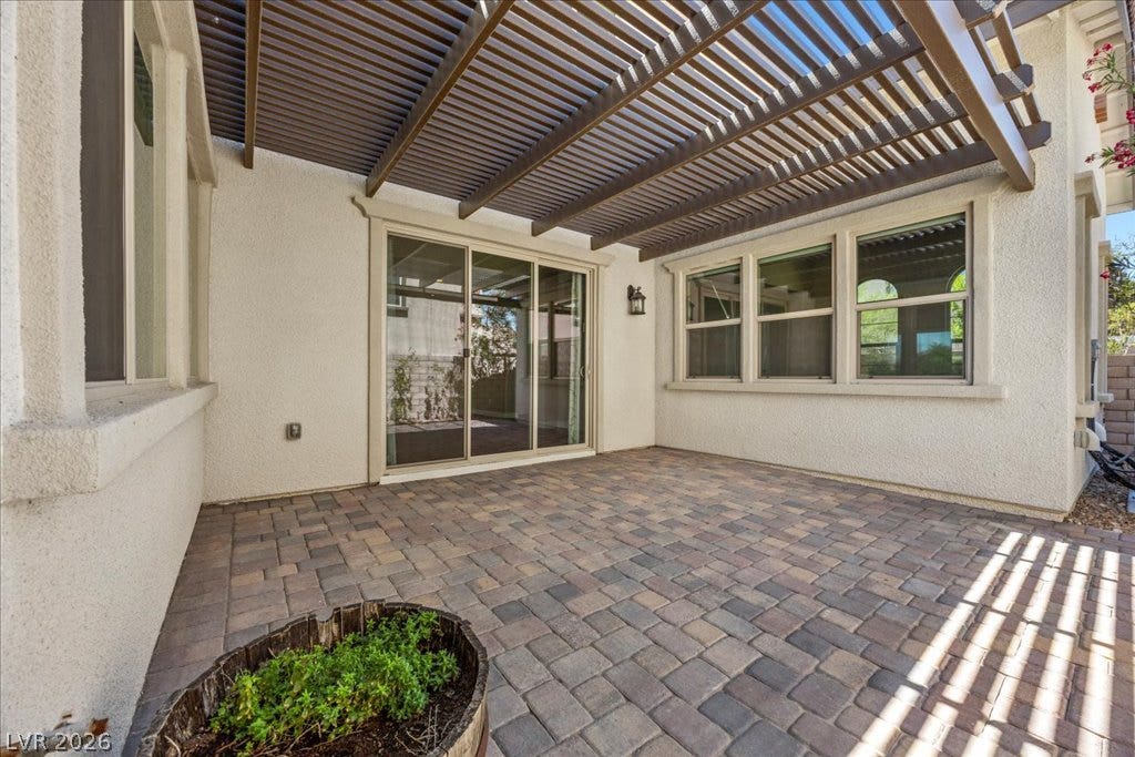 12021 Abbracci Avenue, Las Vegas, NV 89138 A private patio, shielded by a wooden pergola, features robust paver flooring.