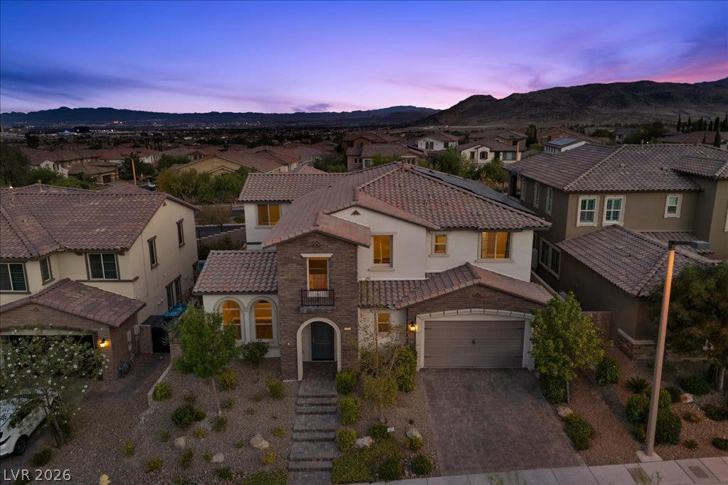 12021 Abbracci Avenue, Las Vegas, NV 89138 An inviting exterior with a brick-paver driveway leads to a contemporary facade with mountain and city views.