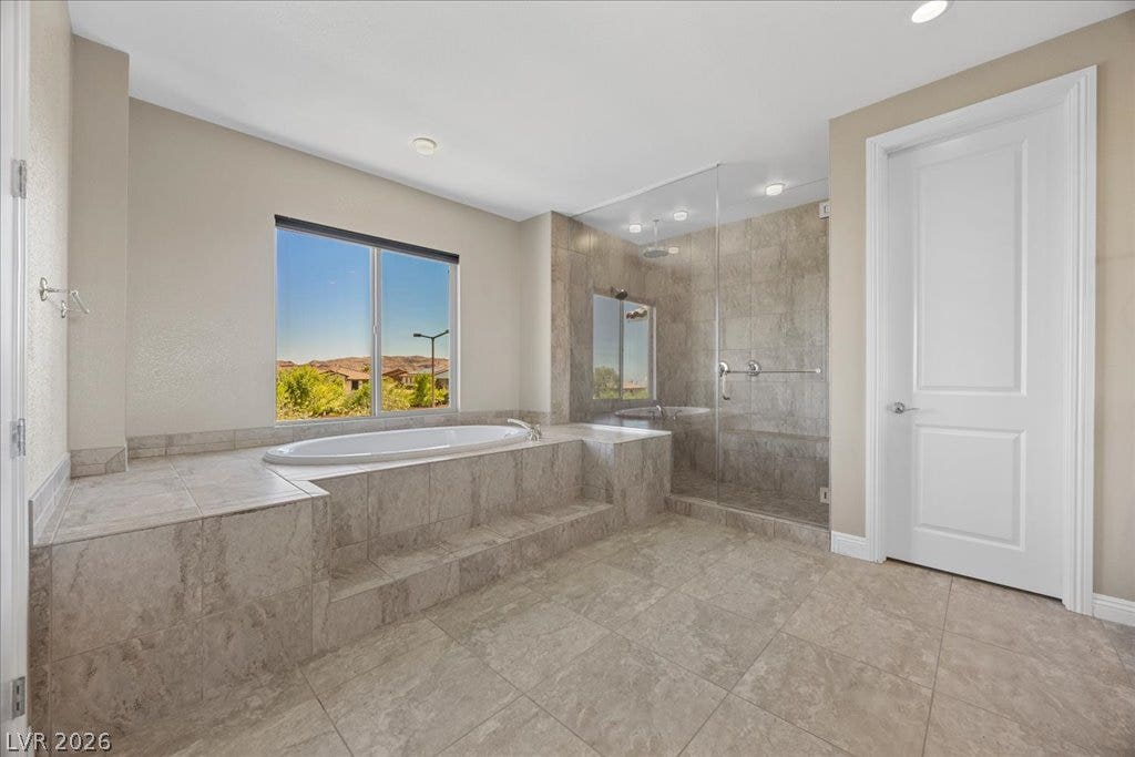 12021 Abbracci Avenue, Las Vegas, NV 89138 Indulge in a tranquil bathing experience in this generous bathroom, featuring a deep soaking tub and a spacious walk-in shower.