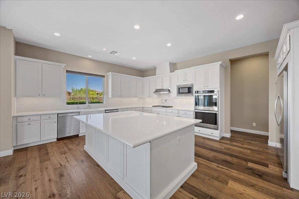 12021 Abbracci Avenue, Las Vegas, NV 89138 White cabinetry and stone countertops elevate this expansive kitchen island with ample meal prep space.