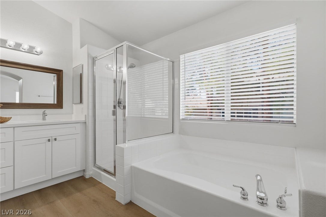 1891 Eagle Flight Lane, Henderson, NV 89012 Natural light fills this space highlighting a deep soaking tub and a glass-enclosed shower.