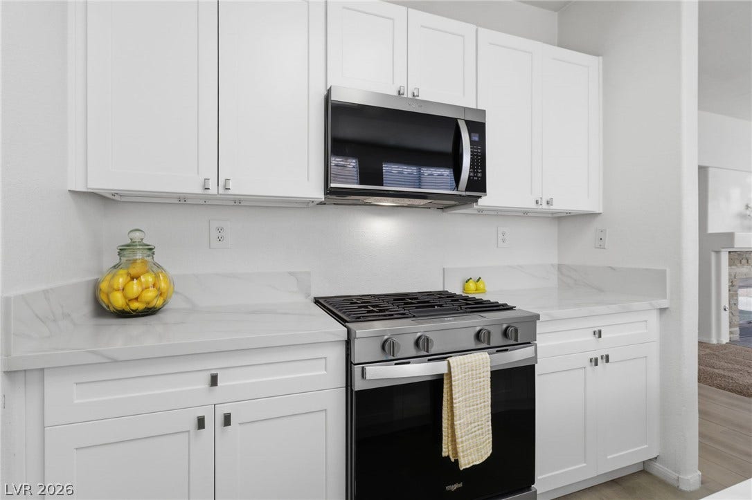 1891 Eagle Flight Lane, Henderson, NV 89012 Sleek stone countertops frame a modern gas range and crisp white cabinetry.