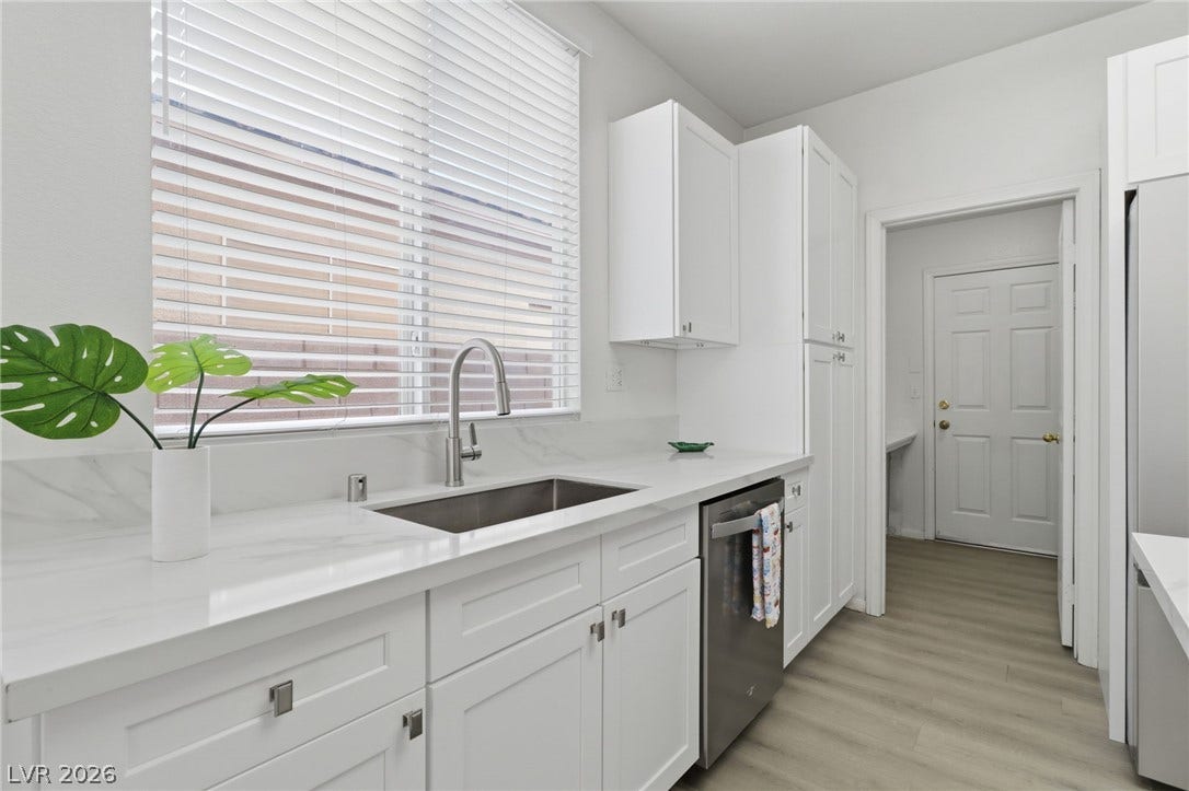 1891 Eagle Flight Lane, Henderson, NV 89012 Sleek stone countertops and pristine white cabinetry define this modern kitchen workspace.