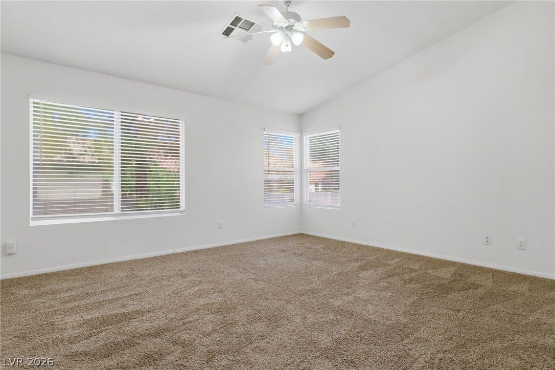 1891 Eagle Flight Lane, Henderson, NV 89012 High vaulted ceilings and soft neutral carpeting define this comfortable primary bedroom space.