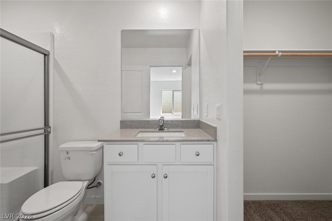 6760 Violet Cascade Avenue, Las Vegas, NV 89156 An integrated vanity features a stone counter adjacent to a walk-in closet space.