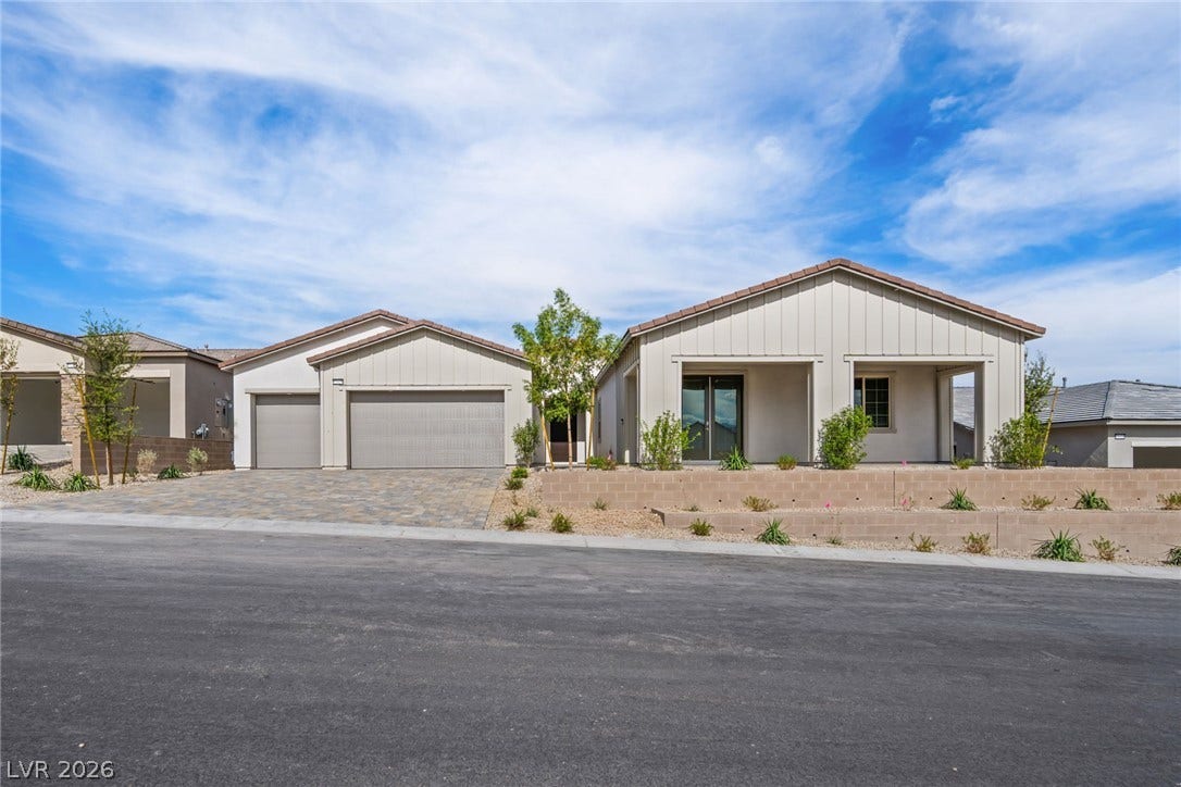 12428 Breezy Bluff Avenue, Las Vegas, NV 89138 Modern desert architecture matches paved driveway parking and a multi-car garage design.